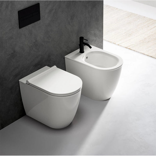 Ceramica Dolomite Coppia sanitari filomuro con sedile in lucido ambientato su piano bagno con accessori