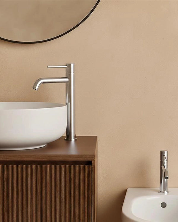 Coppia rubinetti lavabo alto e bidet senza scarico cromo Cromo Lucido ambientato su piano bagno con accessori - Exagonshop