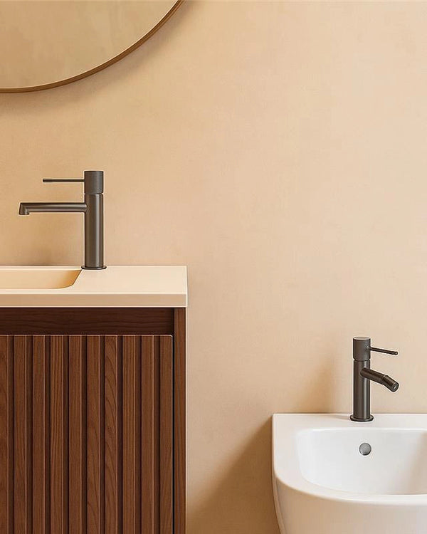 Coppia rubinetti lavabo e bidet senza scarico grigio in ottone ambientato su piano bagno con accessori - Exagonshop