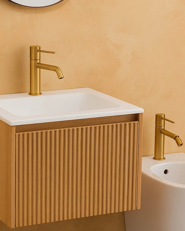 Coppia rubinetti lavabo e bidet senza scarico oro in ottone e satinato ambientato su piano bagno con accessori - Exagonshop