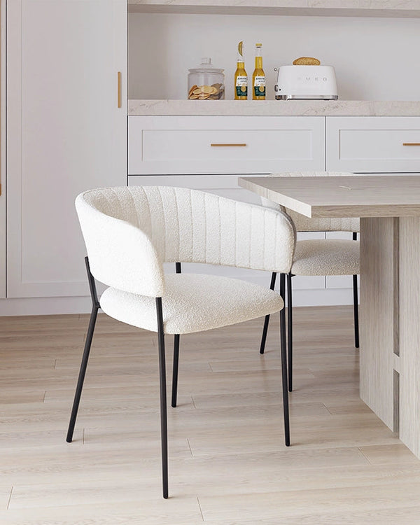 Sedia con braccioli in tessuto boucle imbottito bianco ambientato in spazio living con arredi coordinati - Exagonshop