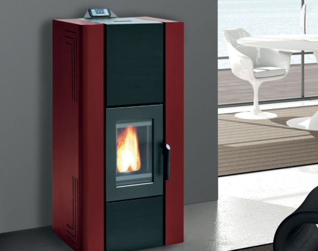 Royal Idro 240 Stufa A Pellet Idro 23kw In Acciaio Rosso accesa in soggiorno, fiamma visibile attraverso il vetro