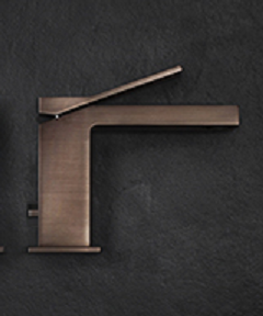 Gessi Rettangolo K Miscelatore lavabo con piletta Copper in pvd ambientato su piano bagno con accessori