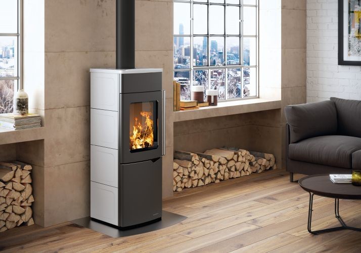 Stufa A Legna ad aria 8kw con porta verticale automatica in Bianca Lucida in ceramica accesa in soggiorno, fiamma...