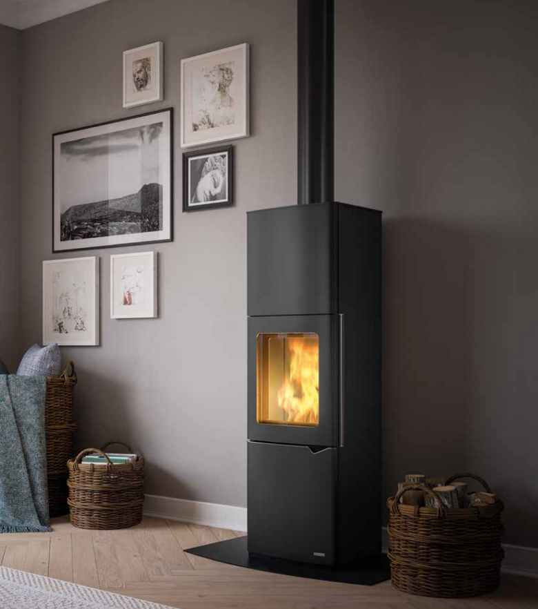 Stufa A Legna ad aria Con Accumulo 7Kw in acciaio in accesa in soggiorno, fiamma visibile attraverso il vetro