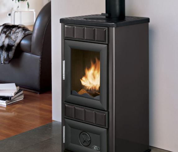 Royal King S Stufa A Legna Ceramicata 6kw 46x40x90 Cm In Grigio accesa in soggiorno, fiamma visibile attraverso il vetro