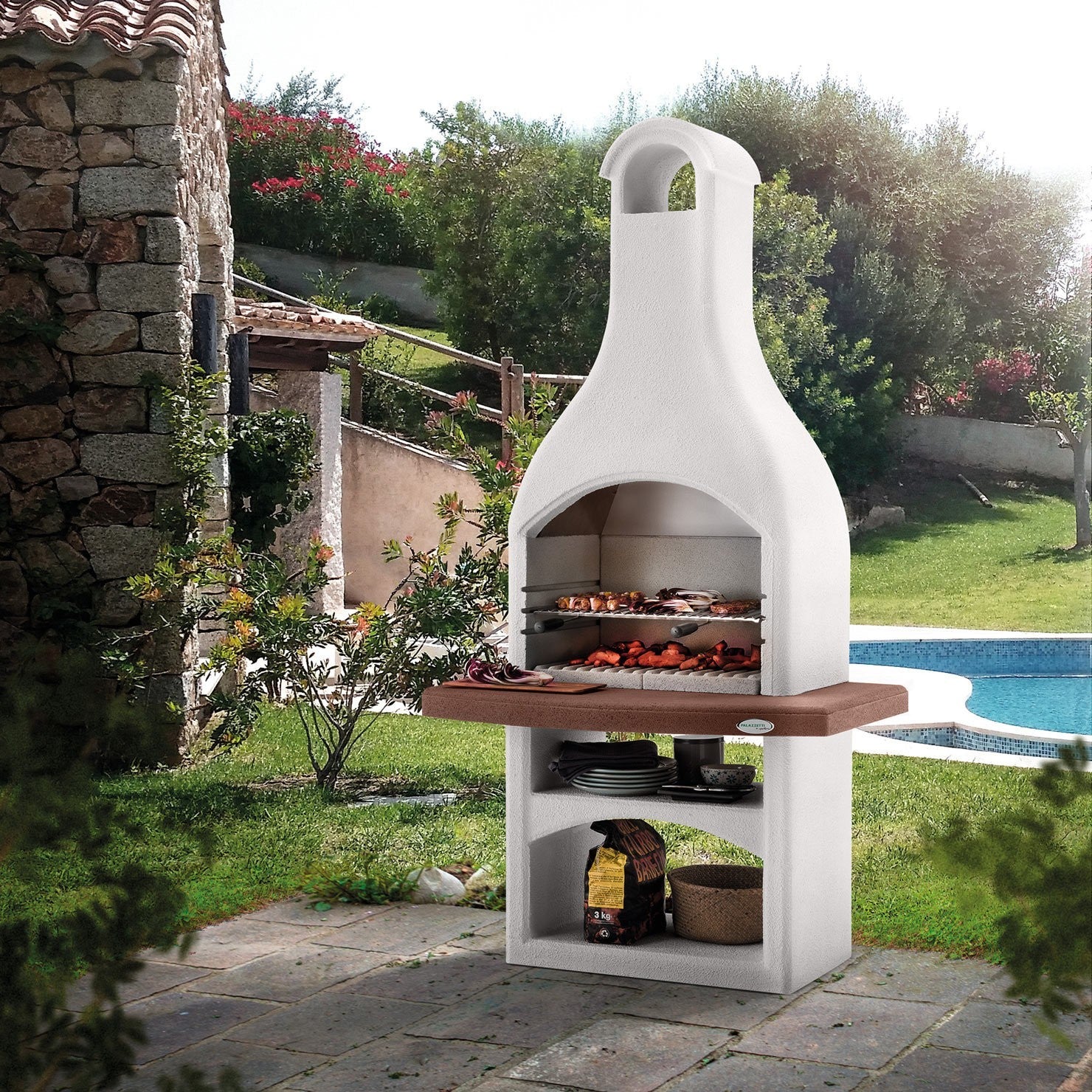 Palazzetti Tirrenia Barbecue In Conglomerato Grezzo accesa in soggiorno, fiamma visibile attraverso il vetro