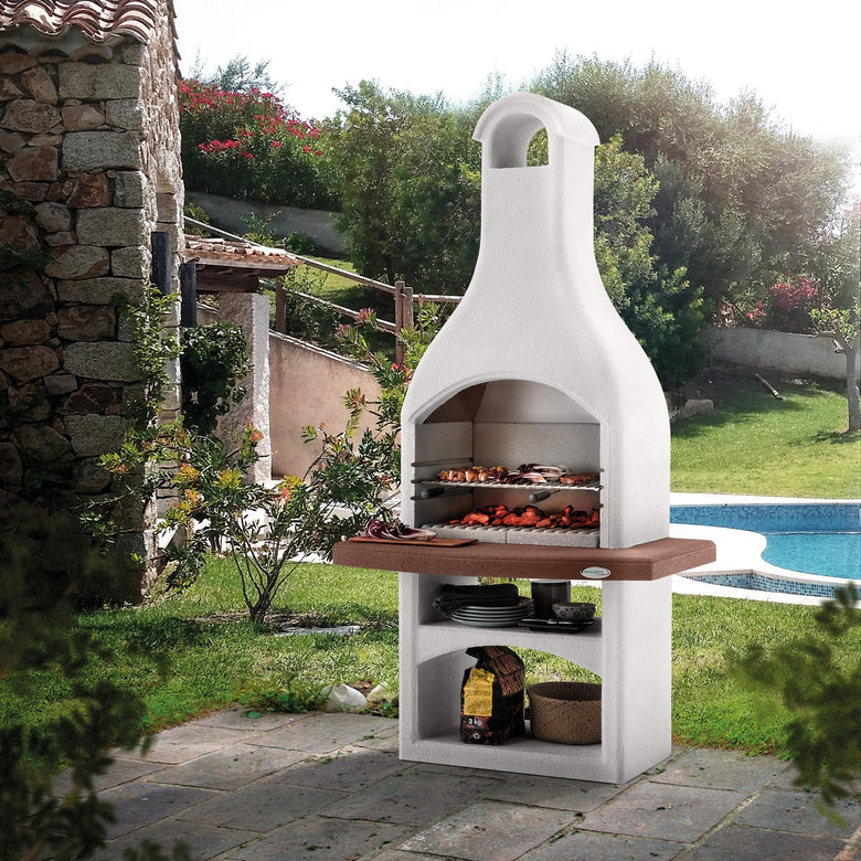 Palazzetti Tirrenia Barbecue In Conglomerato Grezzo accesa in soggiorno, fiamma visibile attraverso il vetro