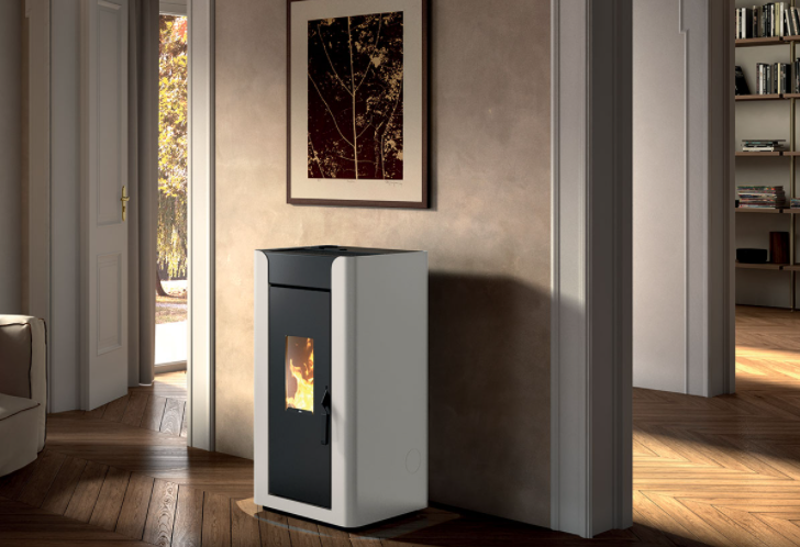 Stufa A Pellet Ad Aria Canalizzabile 12kw In Acciaio Bianco accesa in soggiorno, fiamma visibile attraverso il vetro