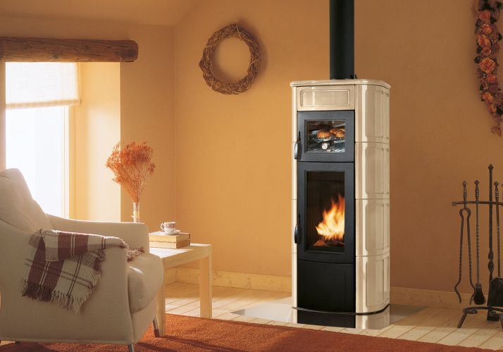 Palazzetti Elisa Stufa A Legna con Forno Con Rivestimento in ceramica accesa in soggiorno, fiamma visibile attraverso il...