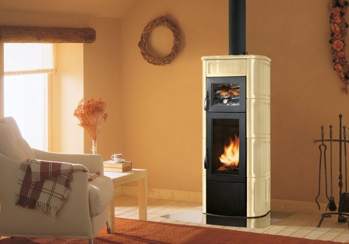 Palazzetti Elisa Stufa A Legna con Forno Con Rivestimento in ceramica accesa in soggiorno, fiamma visibile attraverso il...