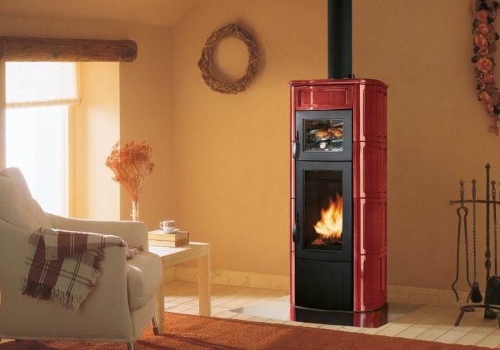 Palazzetti Elisa Stufa A Legna con Forno Con Rivestimento in ceramica accesa in soggiorno, fiamma visibile attraverso il...
