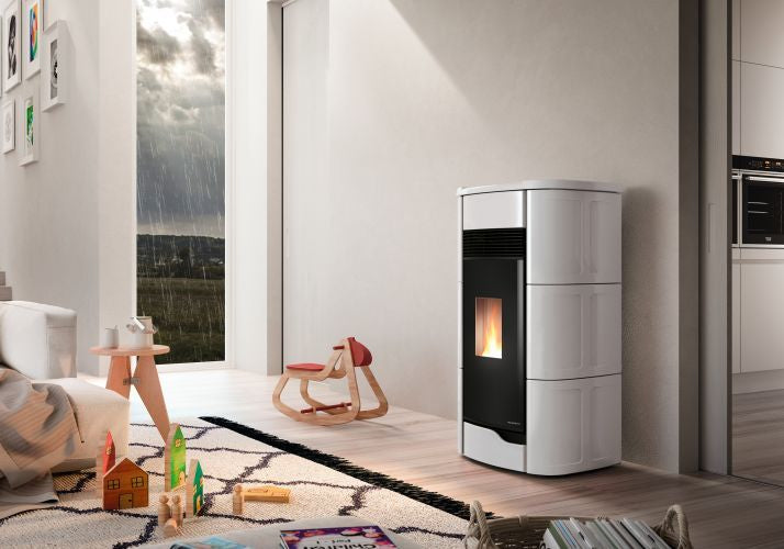 Palazzetti Anna 12 Pro 3 Stufa ermetica A Pellet ad aria in ceramica e ghisa accesa in soggiorno, fiamma visibile...