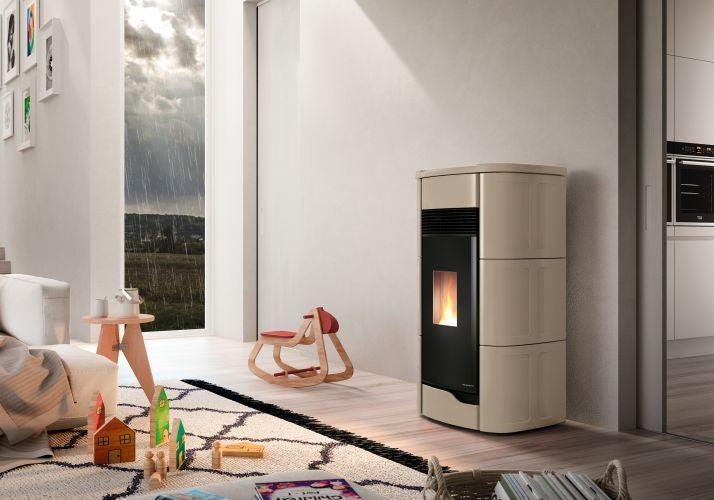 Palazzetti Anna 12 Pro 3 Stufa ermetica A Pellet ad aria in ceramica e ghisa accesa in soggiorno, fiamma visibile...