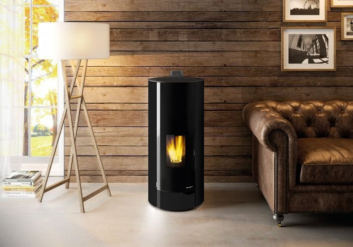 Palazzetti Nina 8 Stufa A Pellet Ecofire ad Aria con porta Nera accesa in soggiorno, fiamma visibile attraverso il vetro