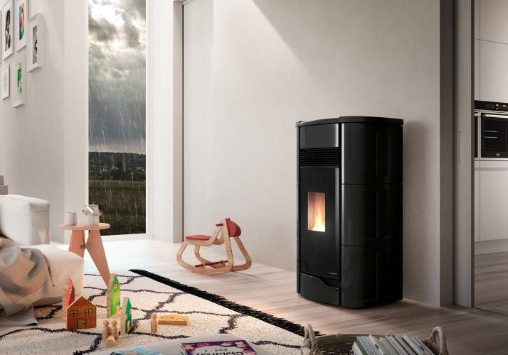 Palazzetti Anna 9 Stufa ermetica A Pellet ad aria 9kw Con Nera in ceramica e ghisa accesa in soggiorno, fiamma visibile...