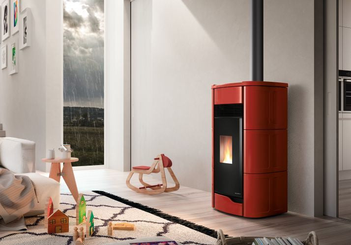 Palazzetti Anna 12 US Pro 2 Stufa A Pellet Ermetica ad aria Rossa in ceramica e ghisa accesa in soggiorno, fiamma...