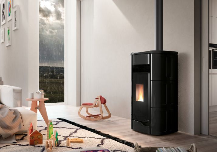 Palazzetti Anna 12 US Stufa a Pellet aria Ermetica con Nera in ceramica e ghisa accesa in soggiorno, fiamma visibile...