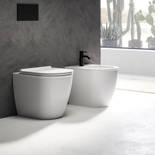 Ceramica Dolomite Coppia sanitari filomuro con sedile in opaco ambientato su piano bagno con accessori
