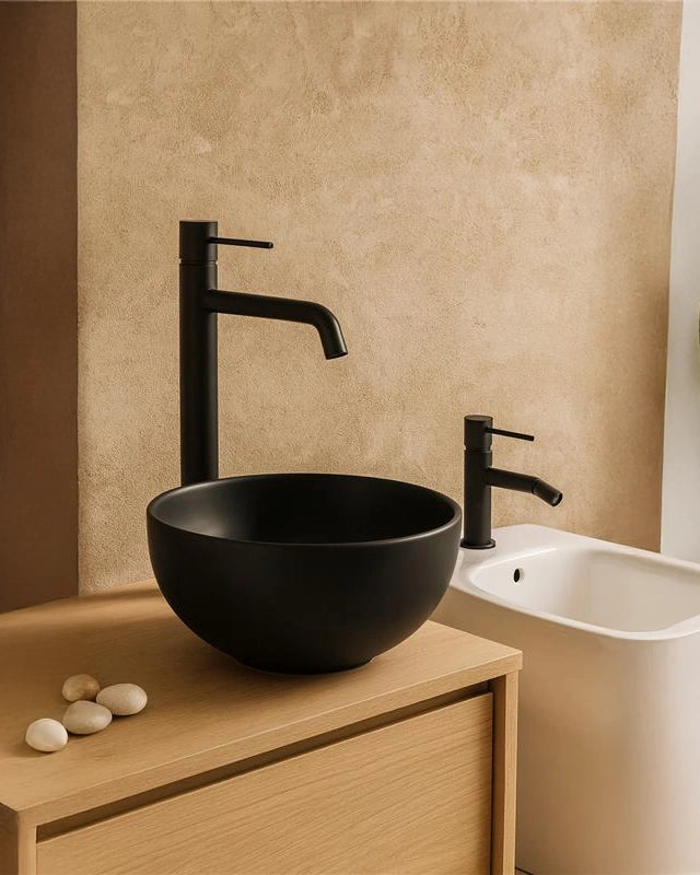 Coppia rubinetti lavabo alto e bidet in ottone nero opaco ambientato su piano bagno con accessori - Exagonshop
