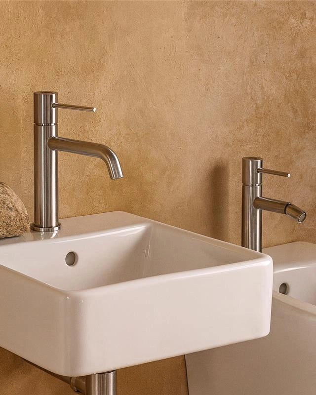 Coppia rubinetti lavabo e bidet in ottone cromo con Cromo Lucido in cromato ambientato su piano bagno con accessori...