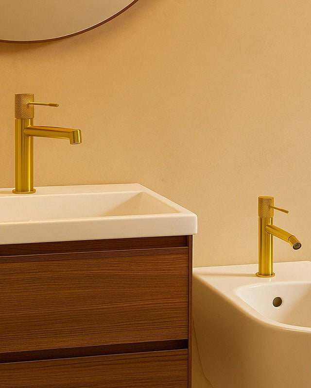 Coppia rubinetti lavabo e bidet senza scarico oro in ottone e spazzolato ambientato su piano bagno con accessori - Exagonshop