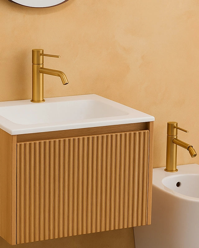 Coppia rubinetti lavabo e bidet senza scarico oro in ottone e satinato ambientato su piano bagno con accessori - Exagonshop