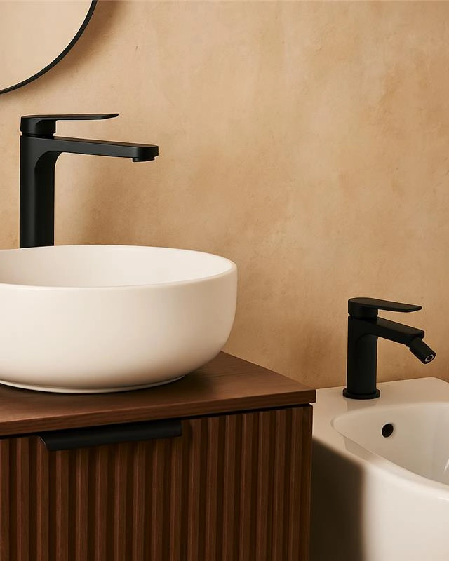 Coppia rubinetti lavabo alto e bidet senza scarico nero in opaco ambientato su piano bagno con accessori - Exagonshop