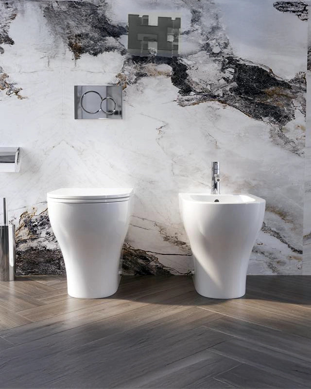 Coppia sanitari Touch a pavimento filo muro bianco lucido in ceramica ambientato su piano bagno con accessori - Exagonshop