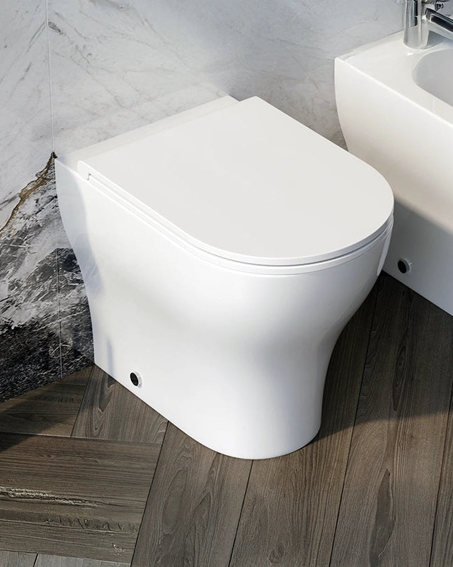 Coppia sanitari Touch a pavimento filo muro bianco lucido ambientato su piano bagno con accessori - Exagonshop