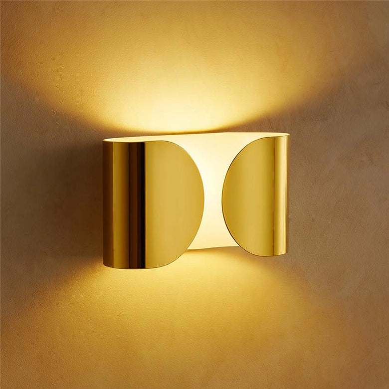 Flos Foglio Lampada da parete in acciaio oro accesa in ambiente, design e diffusione della luce