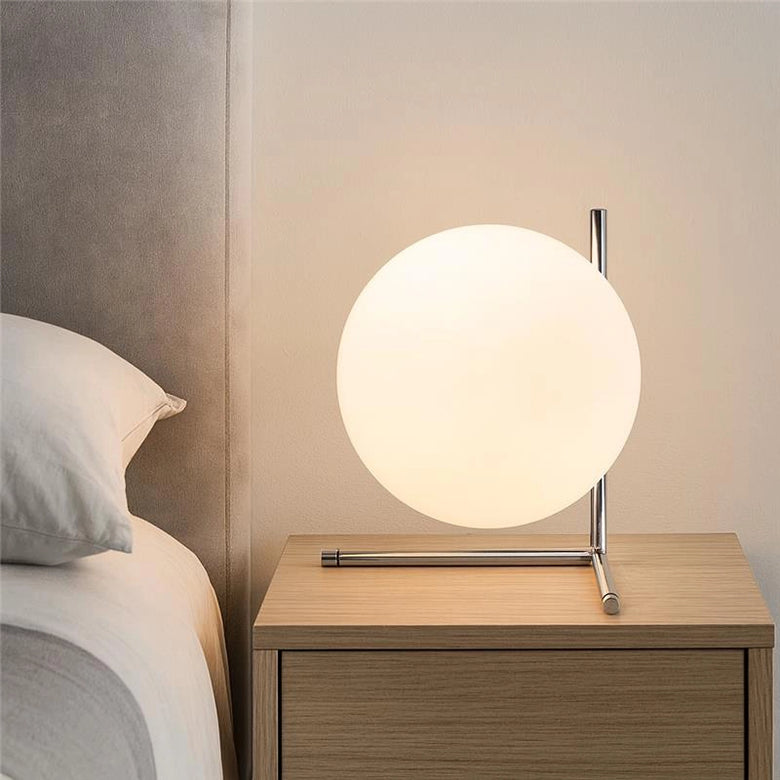 Flos IC Lights Table 2 Low Lampada da comodino cromo in cromato accesa in ambiente, design e diffusione della luce