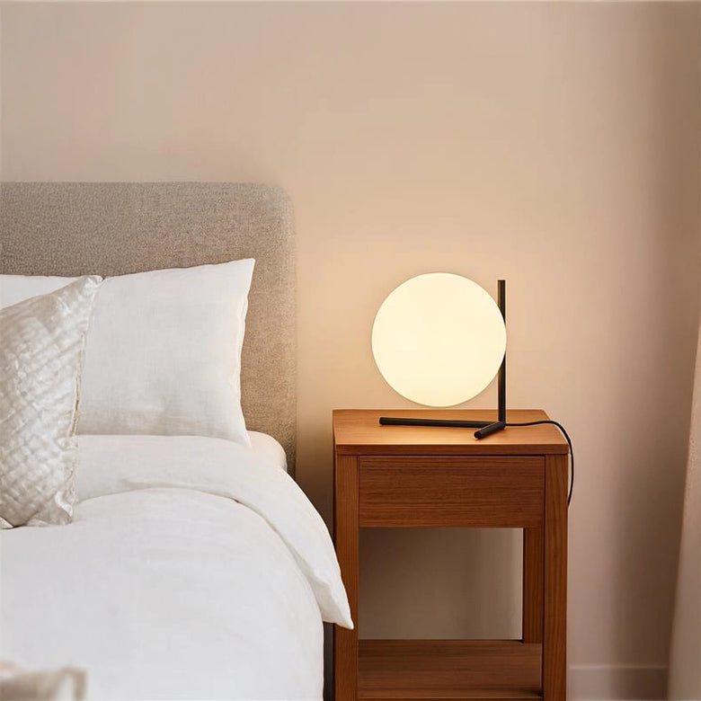 Flos IC Lights Table 2 Low Lampada da comodino nero in ottone accesa in ambiente, design e diffusione della luce