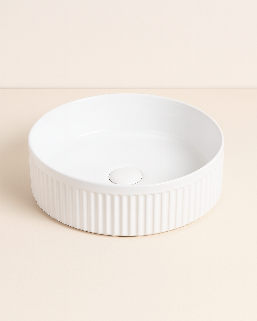 Lavabo 37 cm tondo Roma cannettato da appoggio bianco lucido in ceramica ambientato su piano bagno con accessori - Exagonshop