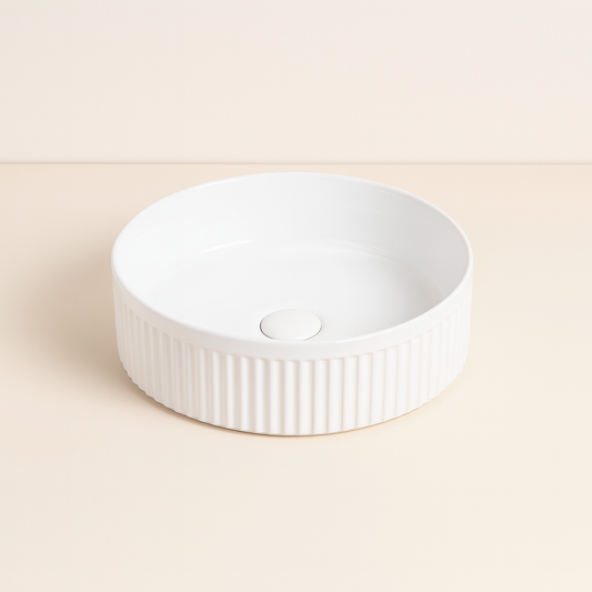 Lavabo 37 cm tondo Roma cannettato da appoggio bianco lucido in ceramica ambientato su piano bagno con accessori - Exagonshop