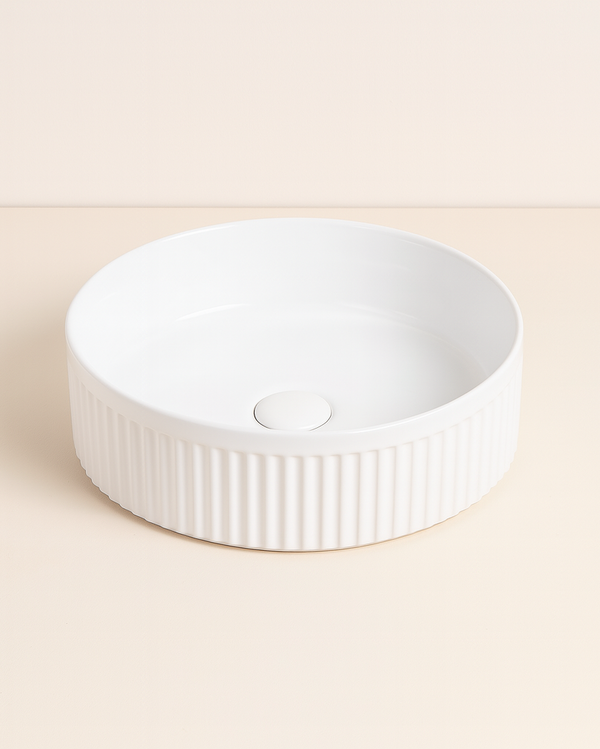 Lavabo 37 cm tondo Roma cannettato da appoggio bianco lucido in ceramica ambientato su piano bagno con accessori - Exagonshop