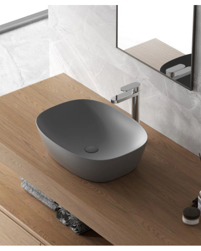 Lavabo a ciotola 50x38 cm grigio opaco in ceramica ambientato su piano bagno con accessori - Exagonshop