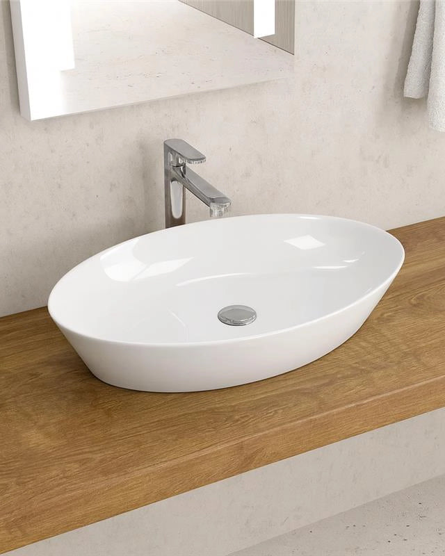 Lavabo ovale 60X36 Da Appoggio In Porcellana Bianca New in naturale ambientato su piano bagno con accessori - Exagonshop