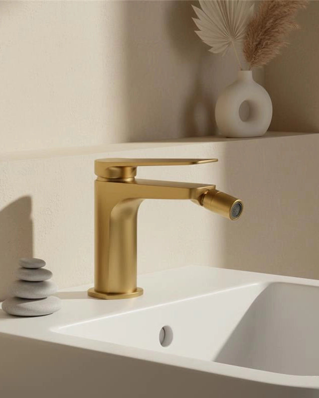 Miscelatore bidet senza scarico in ottone oro spazzolato in ceramica, vista frontale della maniglia e della bocca di...