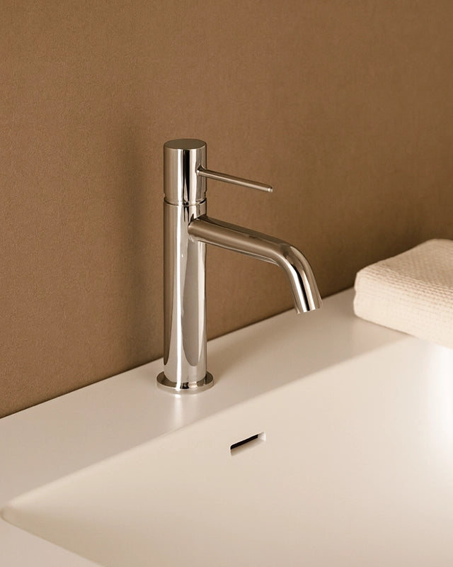 Rubinetto miscelatore lavabo senza scarico in ottone Cromo Lucido in cromato ambientato su piano bagno con accessori...