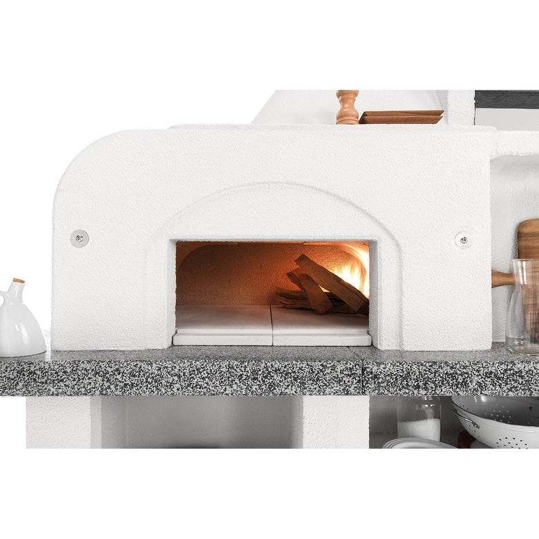 Palazzetti Antille 2 barbecue con forno a legna grezzo accesa in soggiorno, fiamma visibile attraverso il vetro