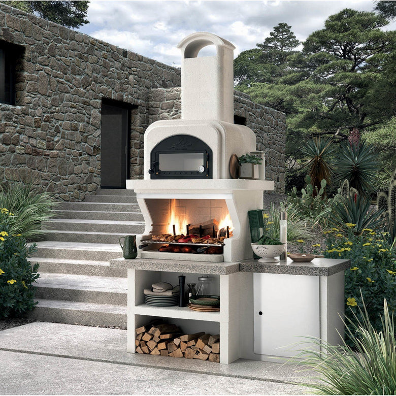 Palazzetti Capri 3 barbecue a legna con forno e piano in in acciaio inox accesa in soggiorno, fiamma visibile attraverso...