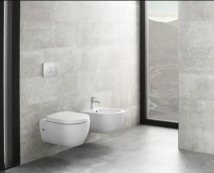 Coppia sanitari sospesi bidet e vaso con sedile rallentato Bianca Lucida in lucido ambientato su piano bagno con accessori