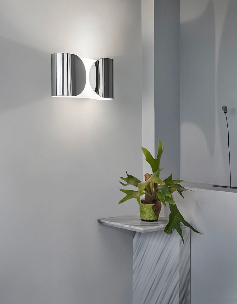 Flos Foglio Lampada da parete in acciaio Cromo accesa in ambiente, design e diffusione della luce