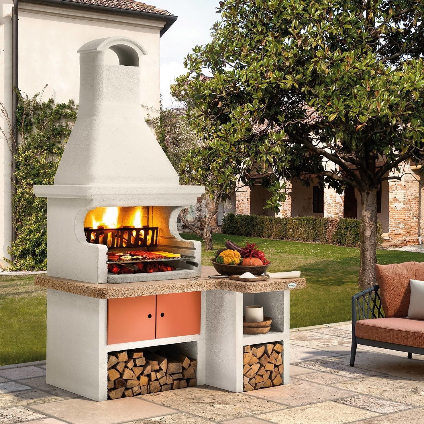 Palazzetti Gallipoli 4 barbecue a legna e carbonella piano accesa in soggiorno, fiamma visibile attraverso il vetro
