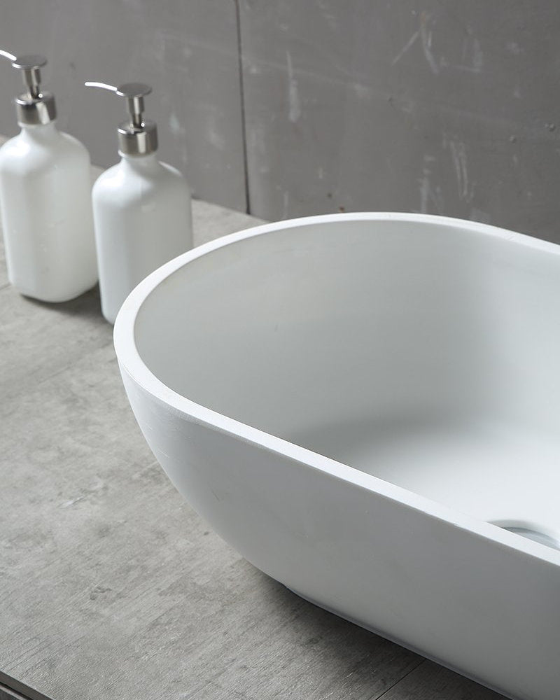 Lavabo 56x32 da appoggio Sondrio solid surface bianco opaco ambientato su piano bagno con accessori - Exagonshop