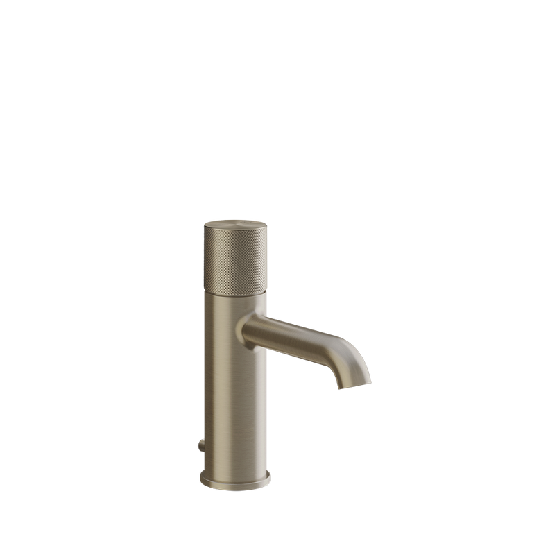 Gessi Miscelatore lavabo con scarico brushed brass ambientato su piano bagno con accessori