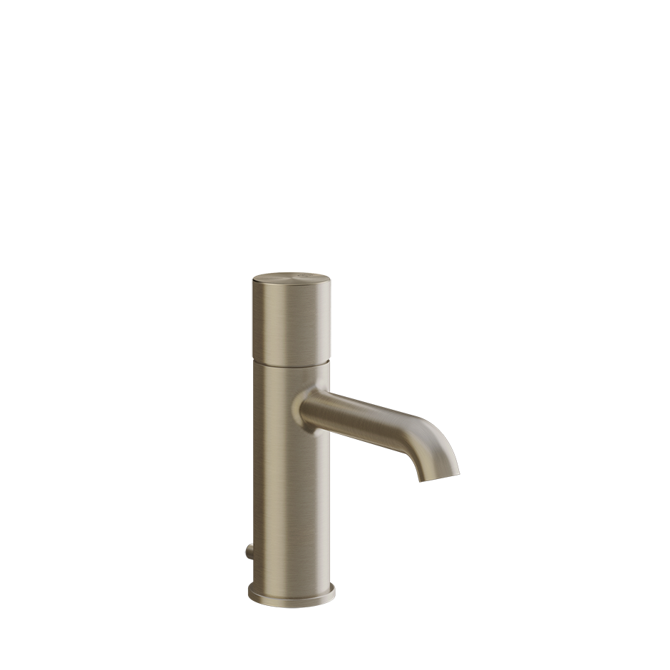 Gessi Habito Miscelatore lavabo con scarico brushed brass ambientato su piano bagno con accessori