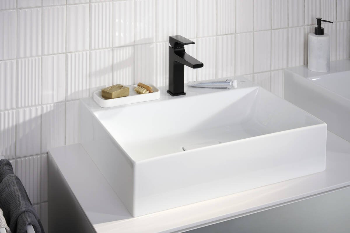 Hansgrohe Metropol Miscelatore lavabo 110 con piletta push in opaco ambientato su piano bagno con accessori