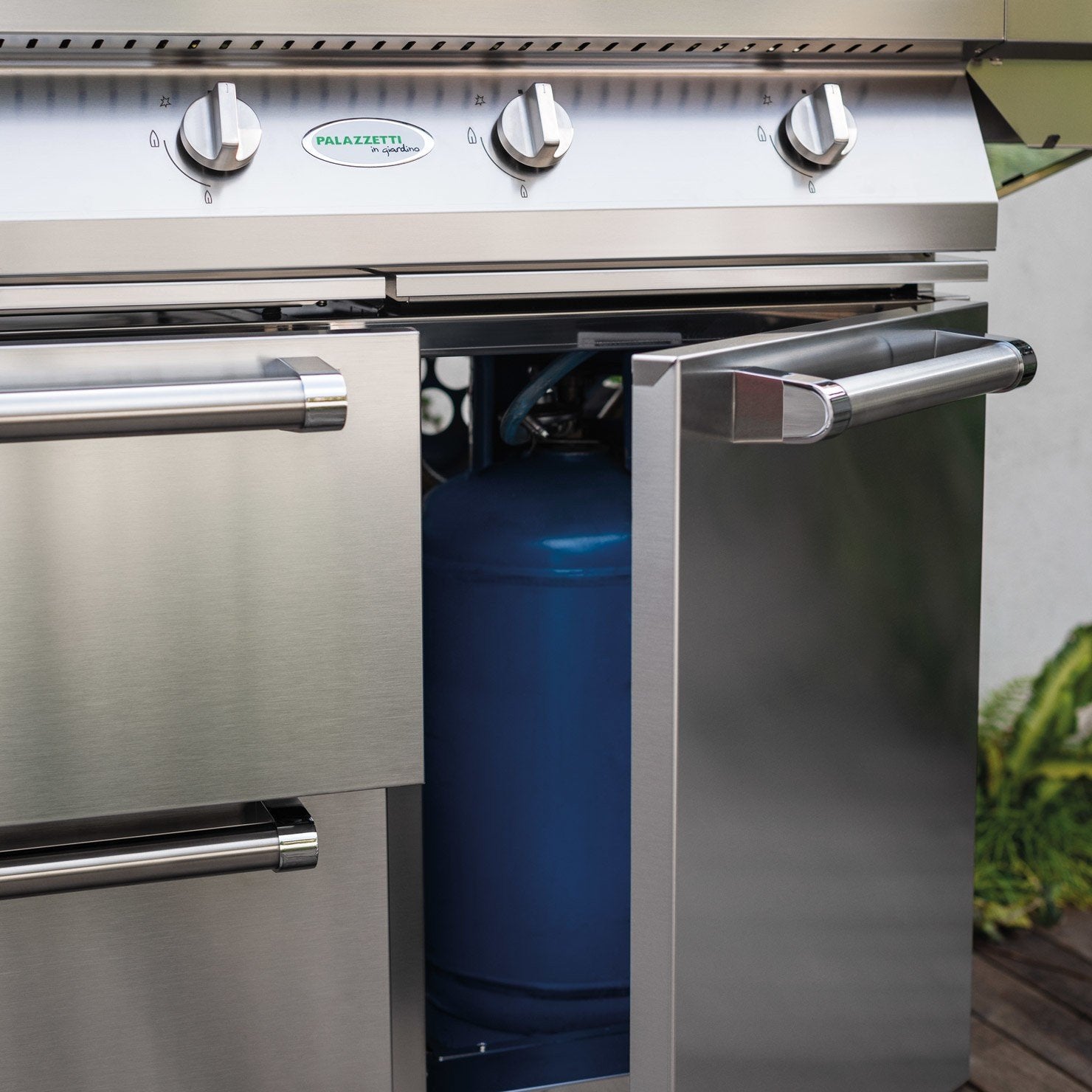 Palazzetti Alain barbecue a gas tre griglie con ruote Acciaio accesa in soggiorno, fiamma visibile attraverso il vetro
